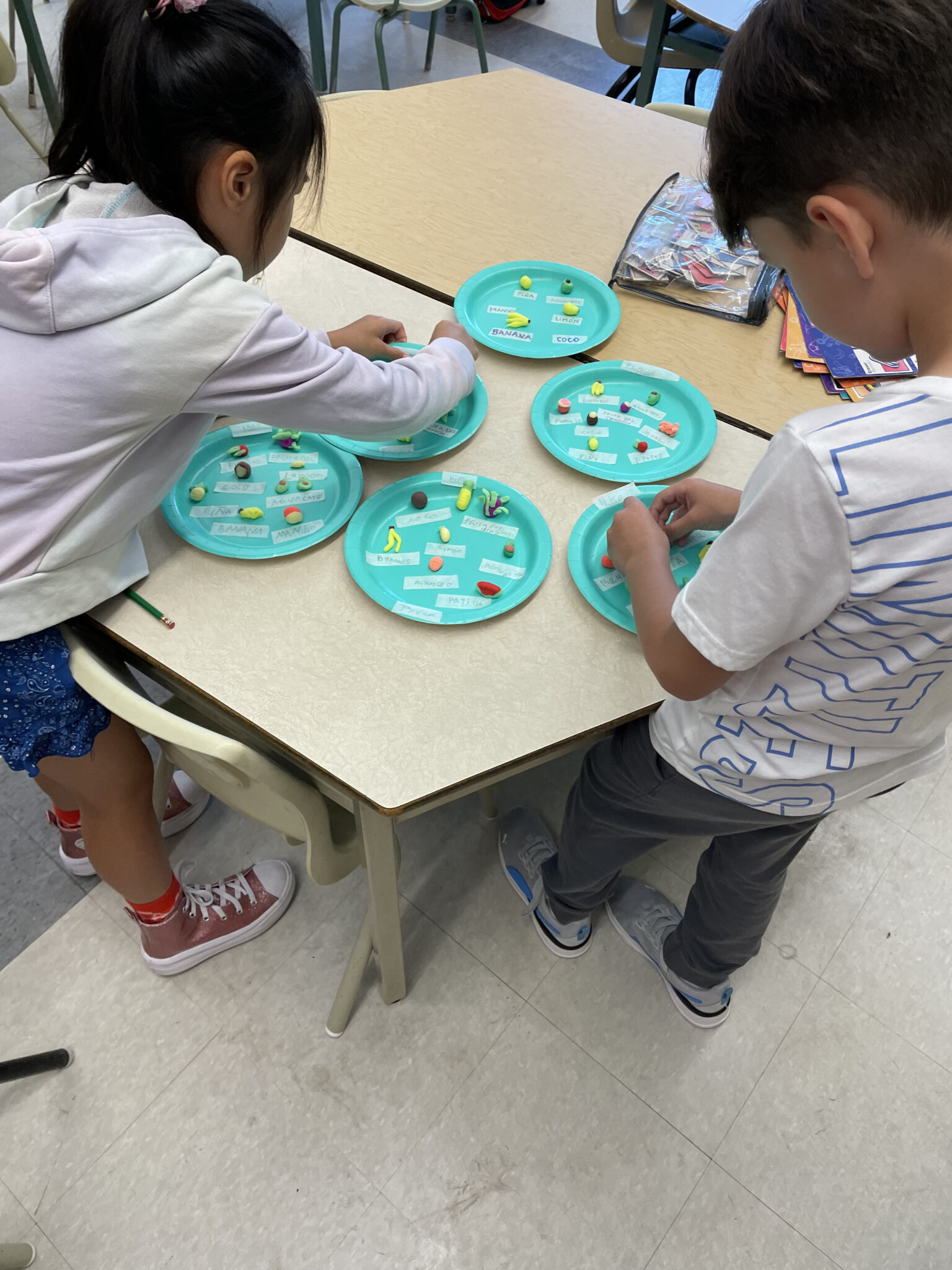 two kids working with playdough in the spanish class